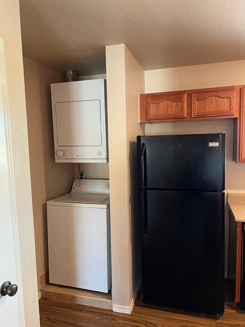 a small kitchen with a refrigerator and a washer and dryer