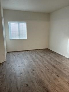 an empty room with wooden floors and a window