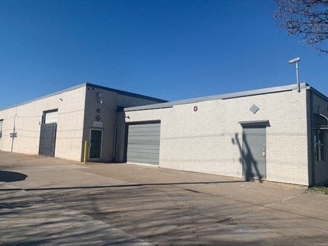 a white brick building with two garage doors