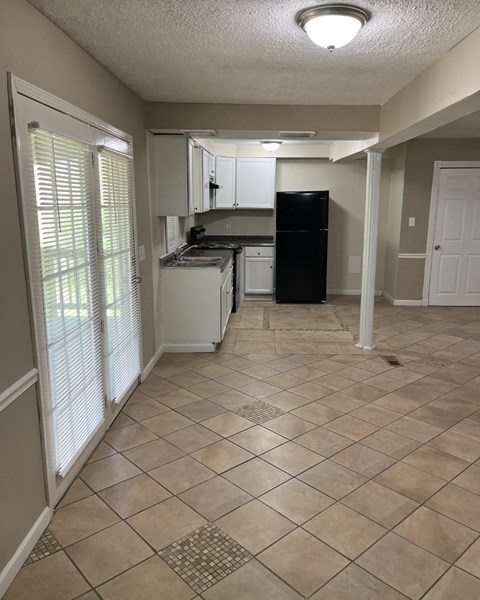 A kitchen with black appliances and white cabinets.