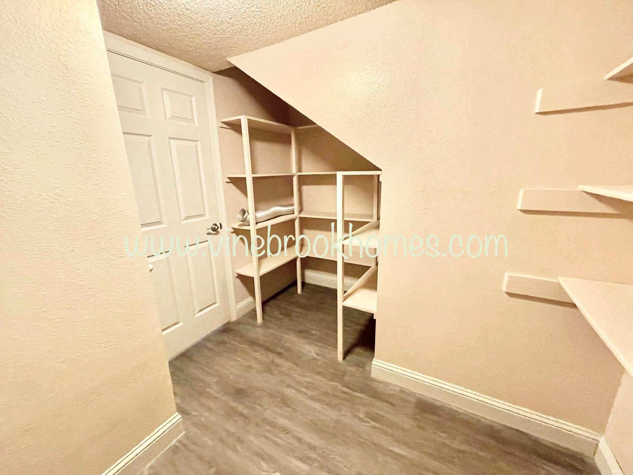 a closet in a small room with shelves and a door