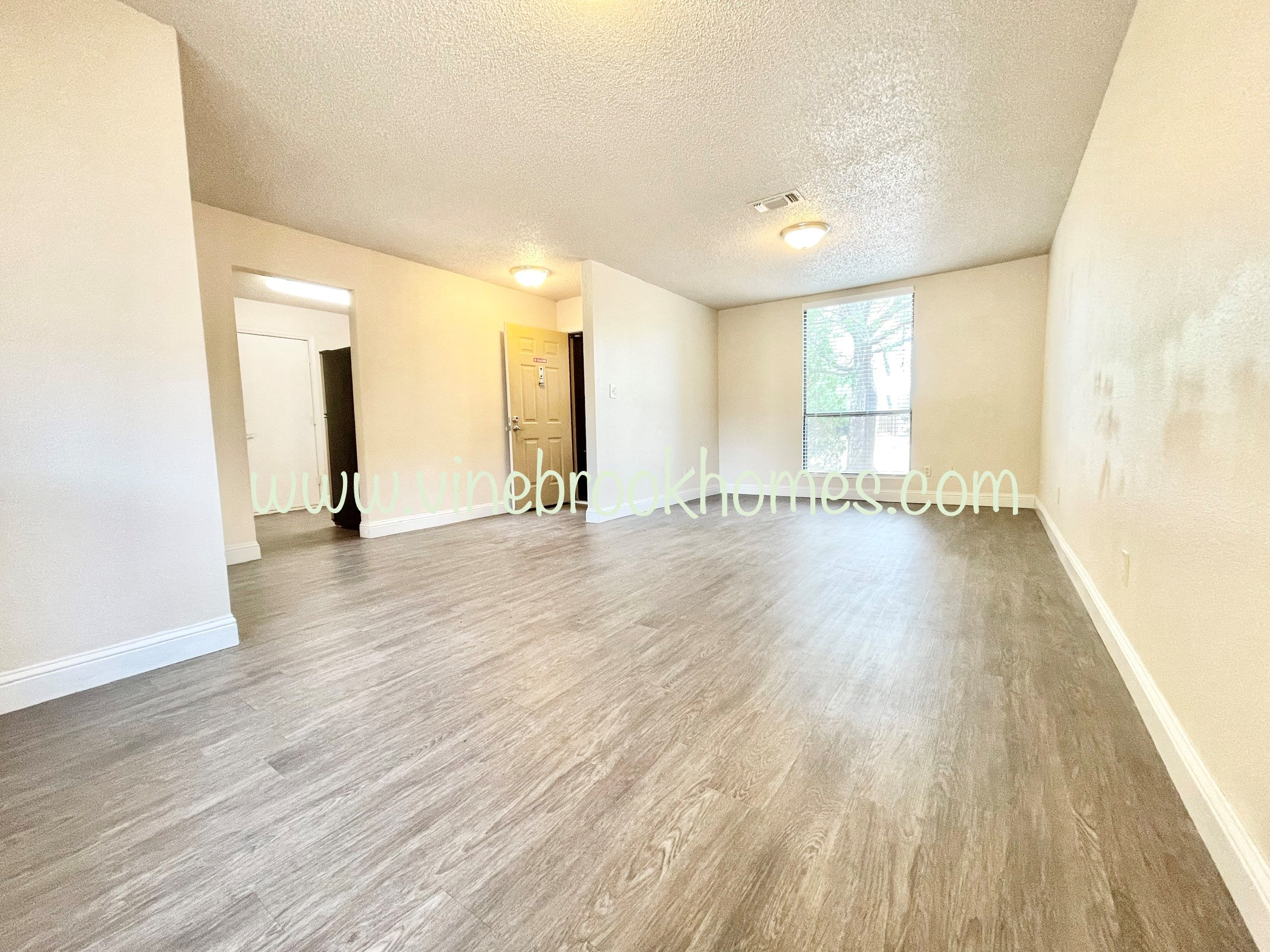 an empty living room with white walls and wood floors