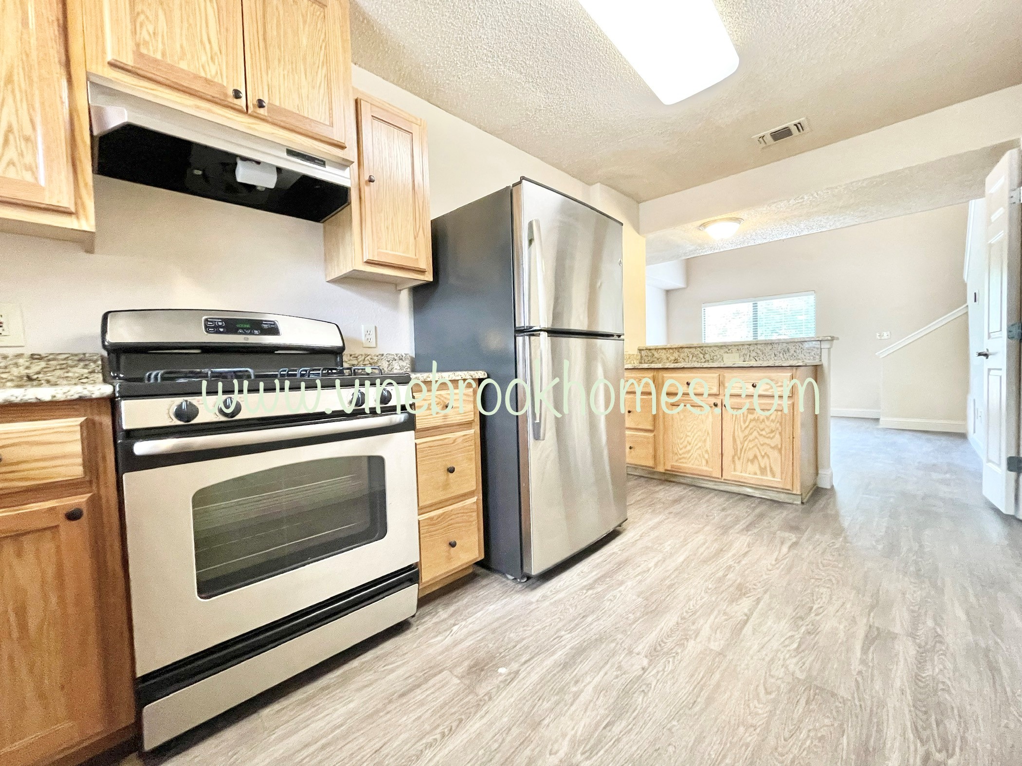 a kitchen with stainless steel appliances and wooden cabinets