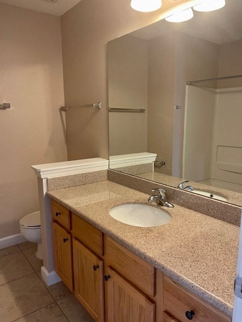 A bathroom with a sink, toilet, and mirror.