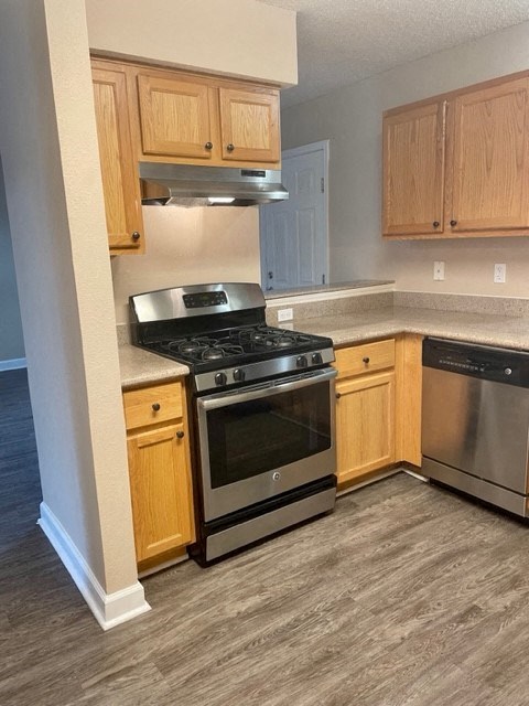 A kitchen with a stove top oven and a dishwasher.