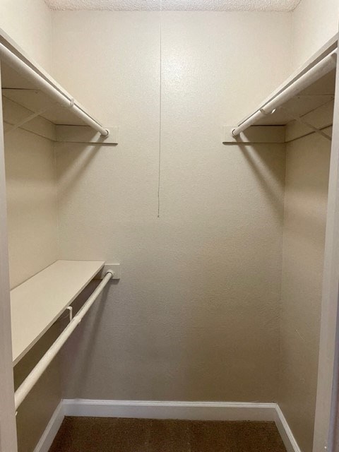 Empty white shelves in a small, white closet.