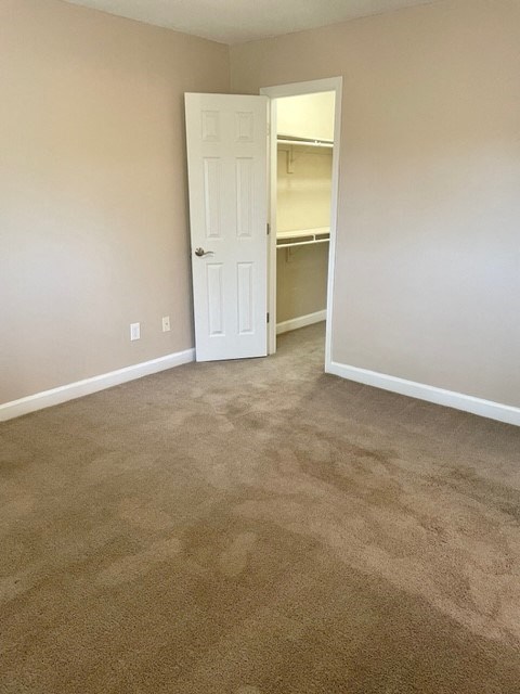 A room with a white door and carpeted floor.