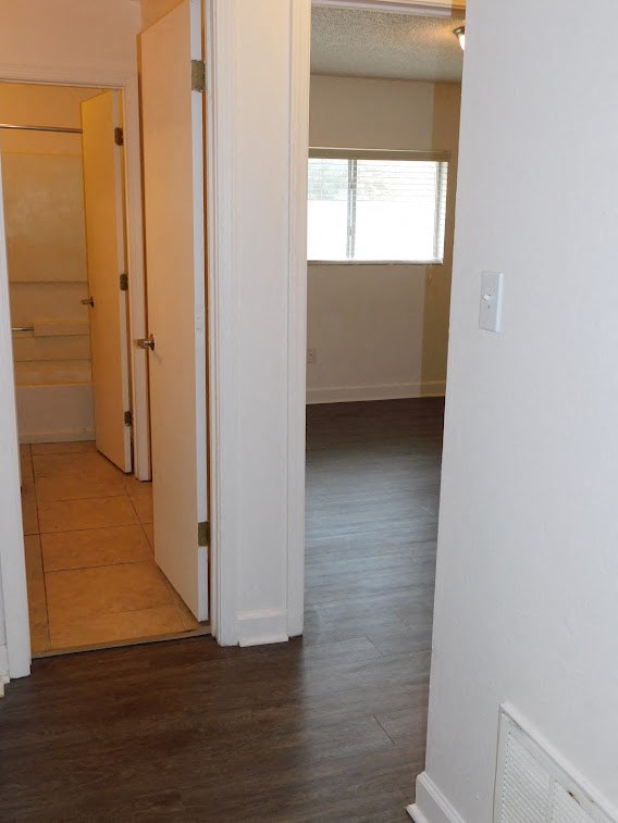 an empty room with a hard wood floor and a window