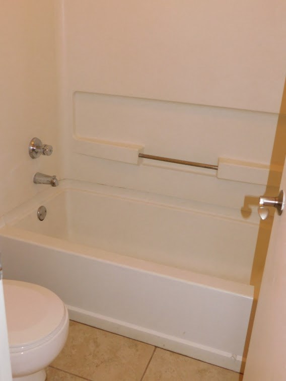 a bathroom with a white bath tub and a toilet