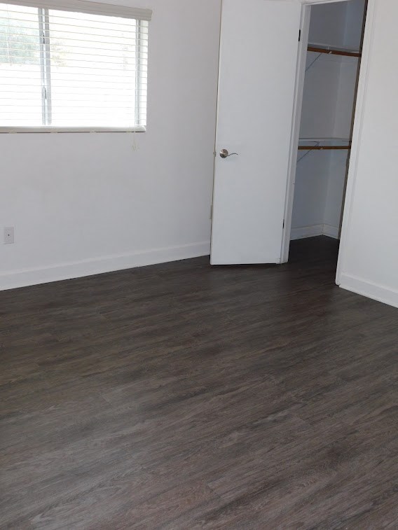 an empty room with wood flooring and a closet