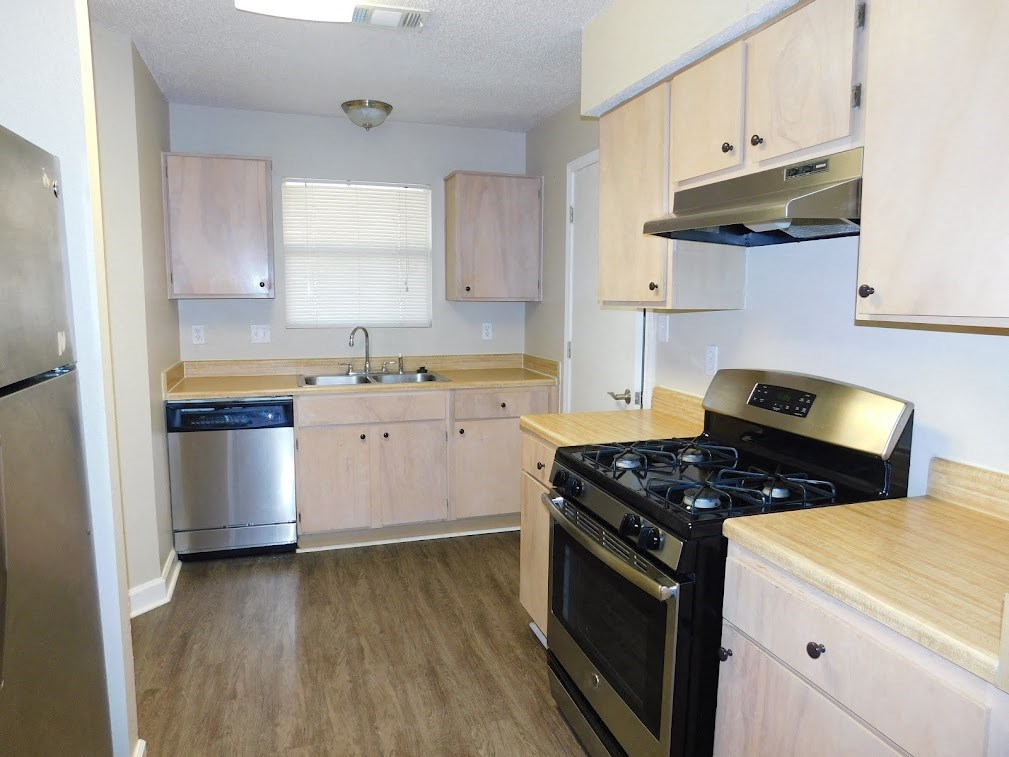 an empty kitchen with a stove and a refrigerator