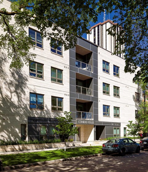 a white apartment building with a car parked in front of it