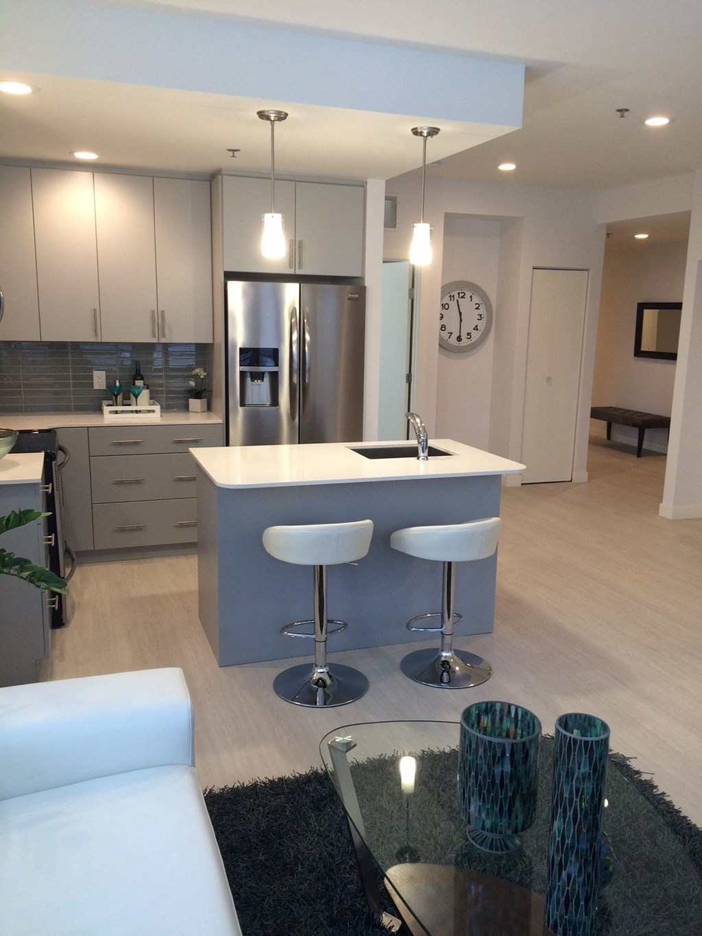 an open kitchen and living room with a blue island with three stools