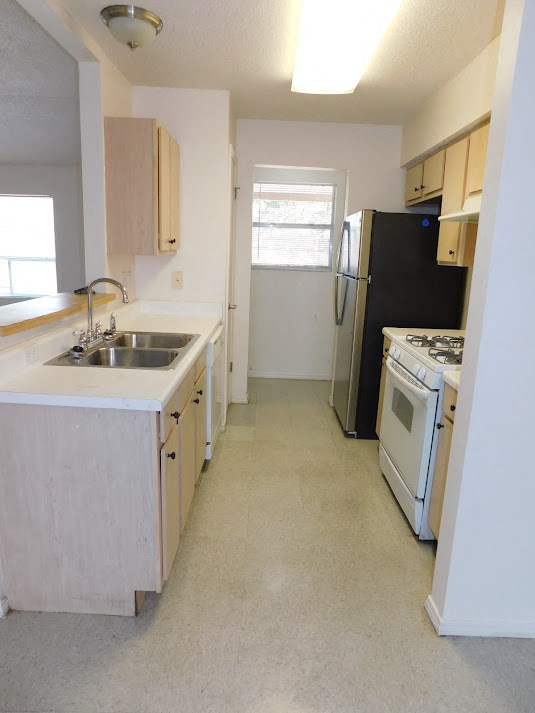a kitchen with a sink and a stove and a refrigerator