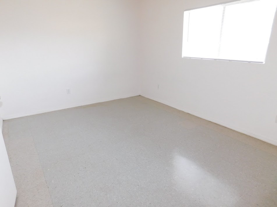 an empty room with white walls and a window