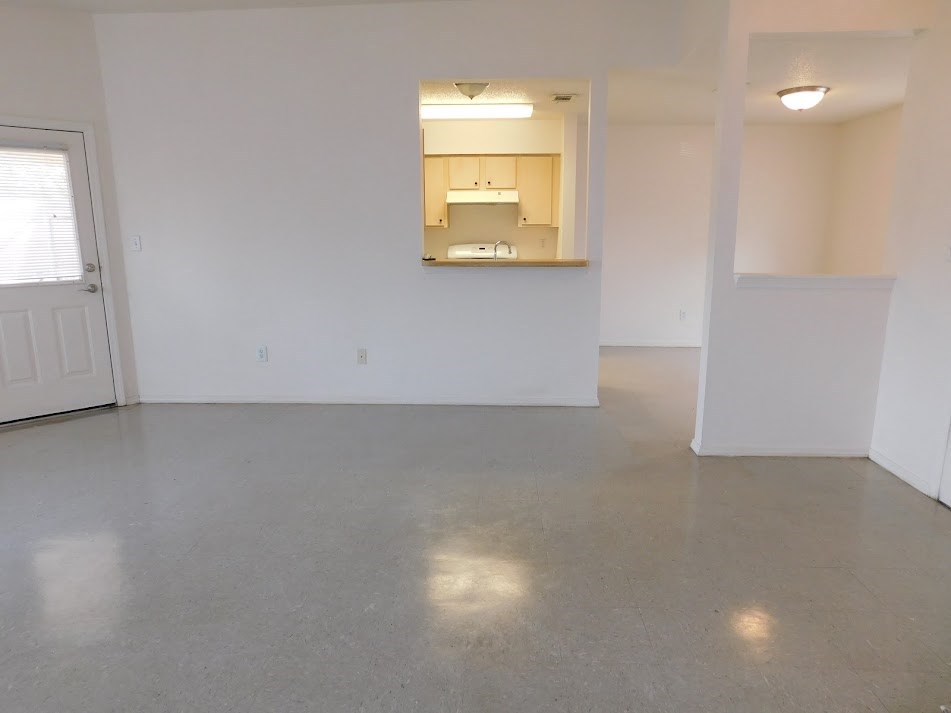 an empty living room with white walls and a concrete floor