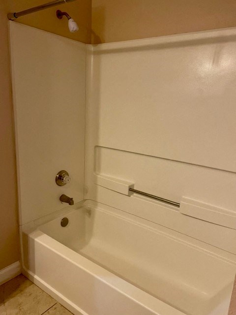 a white bathroom with a tub and a shower