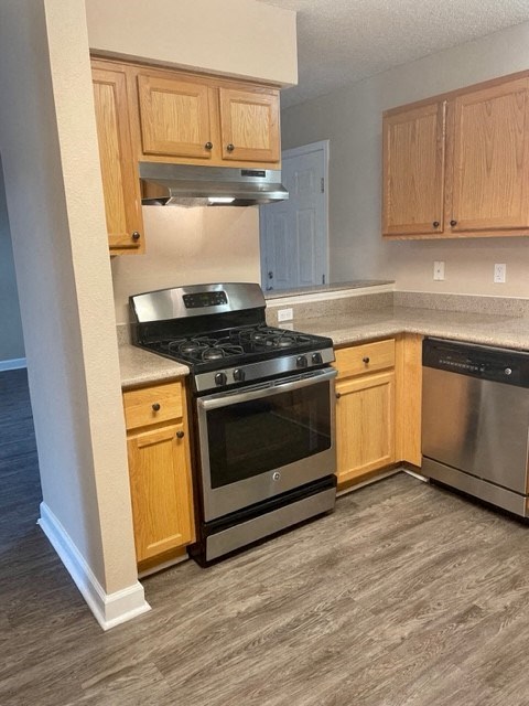 a kitchen with stainless steel appliances and wooden cabinets
