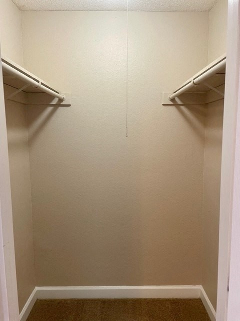 an empty closet with two empty shelves on the wall