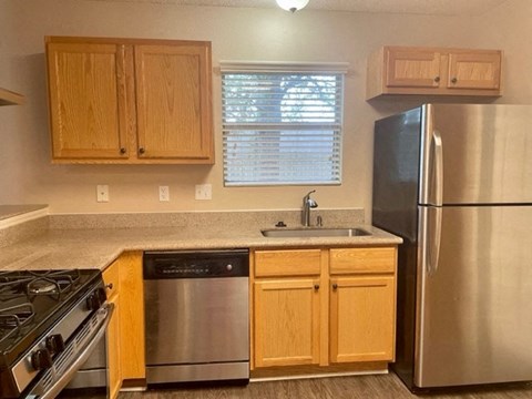 a kitchen with a stainless steel refrigerator and a sink