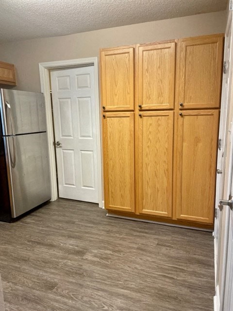 a kitchen with wooden cabinets and a stainless steel refrigerator