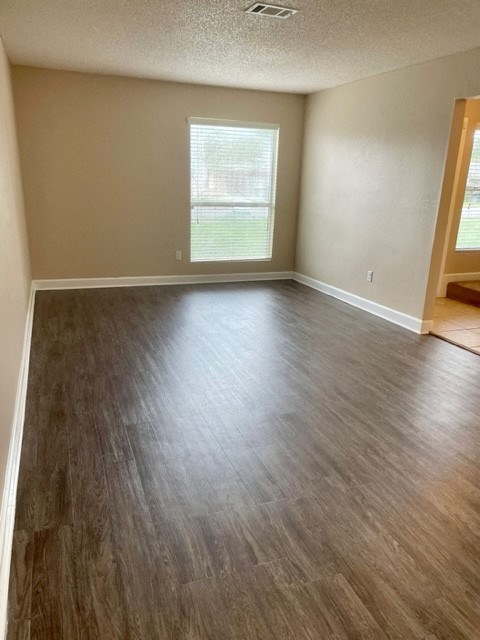 an empty living room with a hard wood floor
