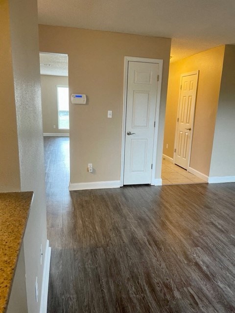 an empty living room with wood floors and a white door