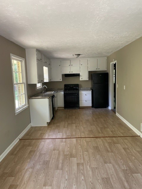 an empty kitchen with a hard wood floor