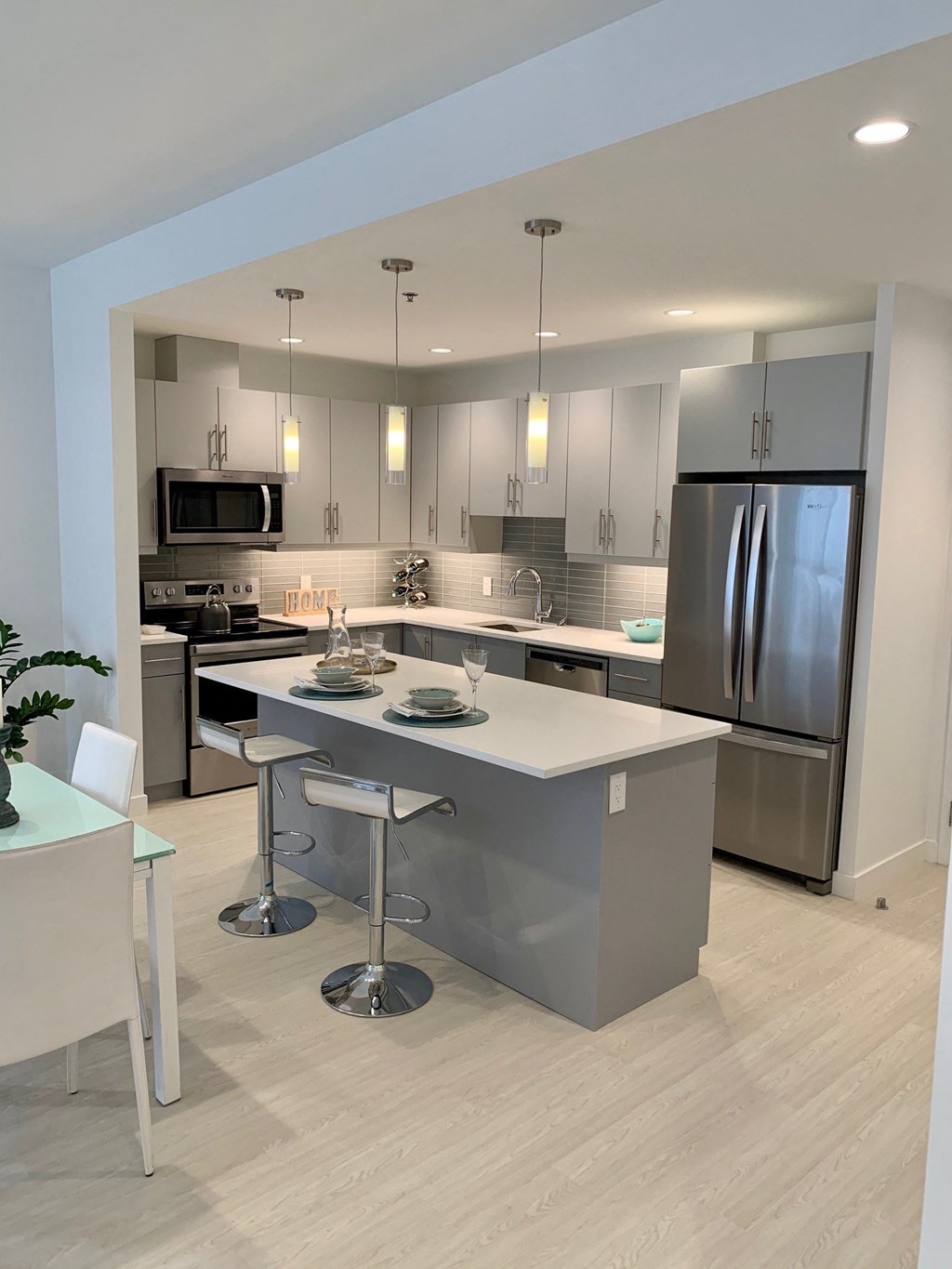 a kitchen with a large island and stainless steel appliances