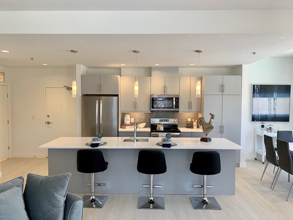 a kitchen with an island and a bar with four chairs