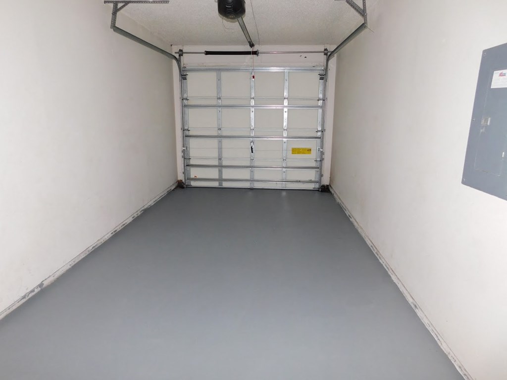 A large garage door is closed and the garage is empty.