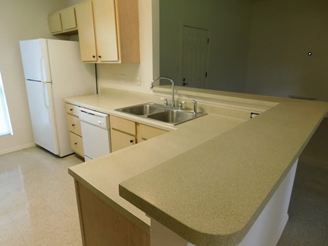 a kitchen with an island and a sink and a refrigerator