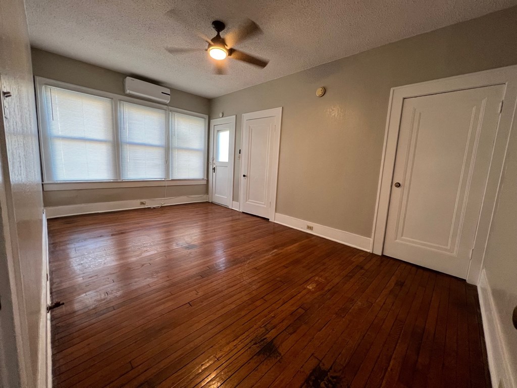 A room with wood floors and a ceiling fan.