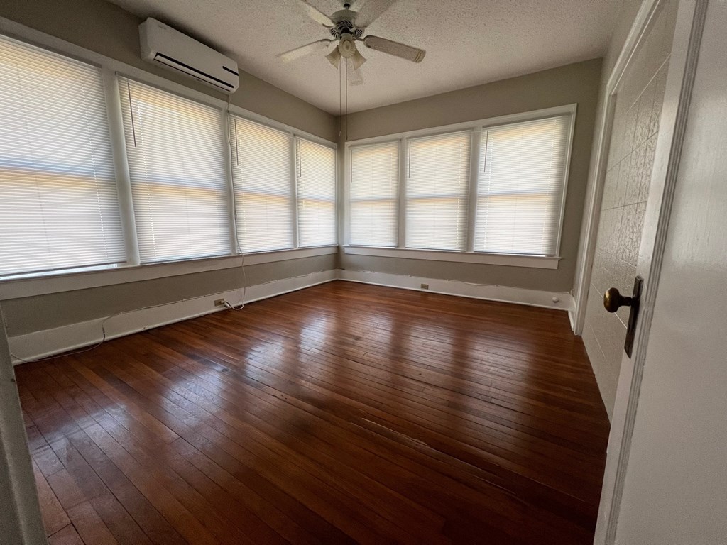 A room with wooden floors and a ceiling fan.
