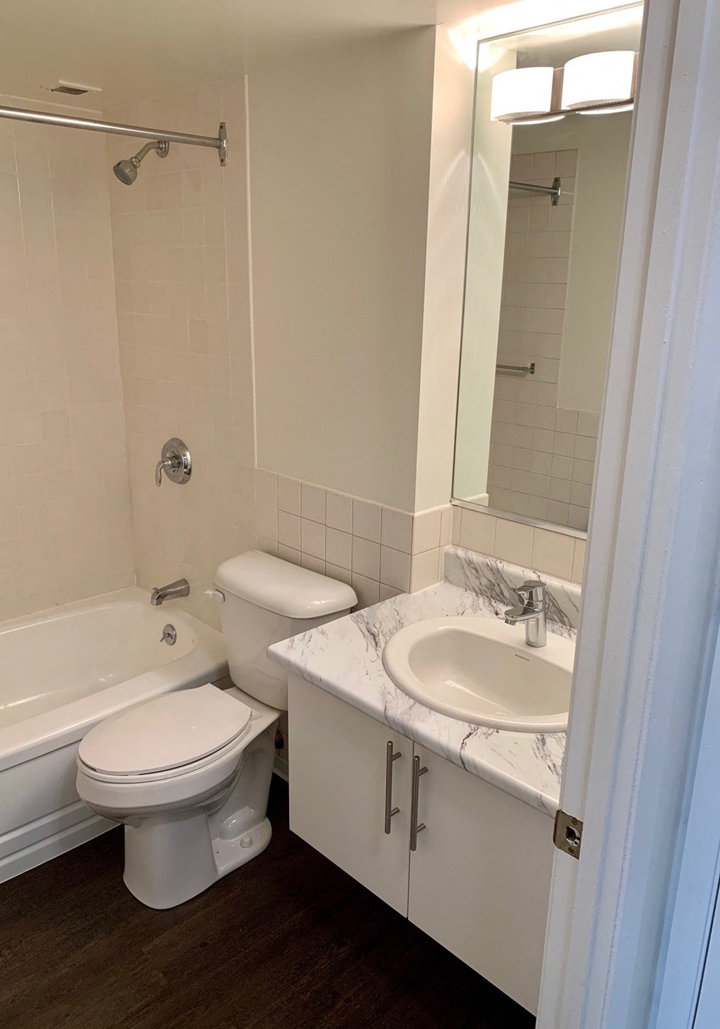 a bathroom with a toilet sink and tub and a mirror