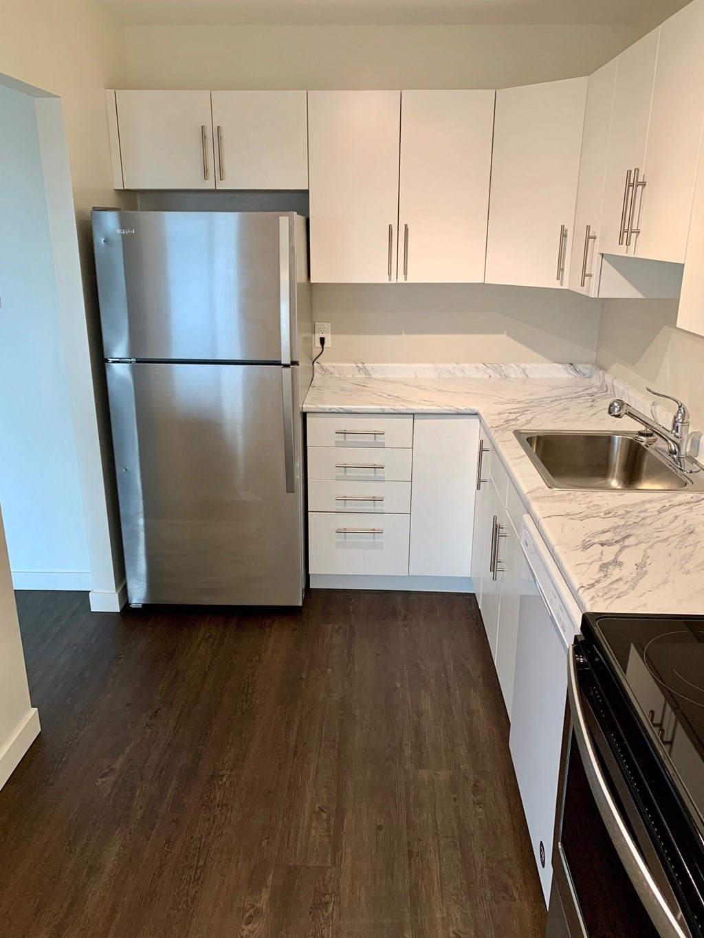 a kitchen with white cabinets and a stainless steel refrigerator