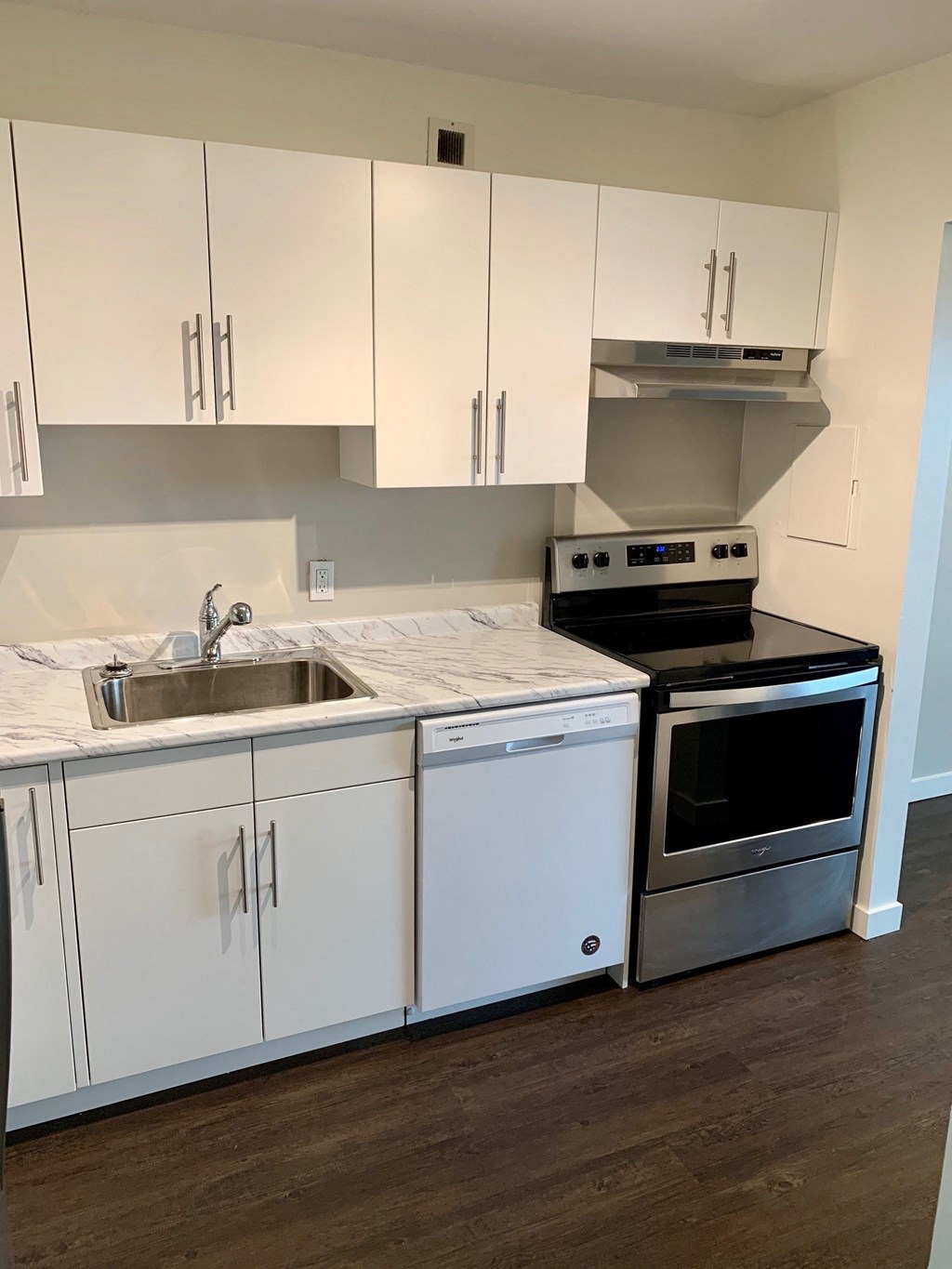 a kitchen with white cabinets and stainless steel appliances and a sink
