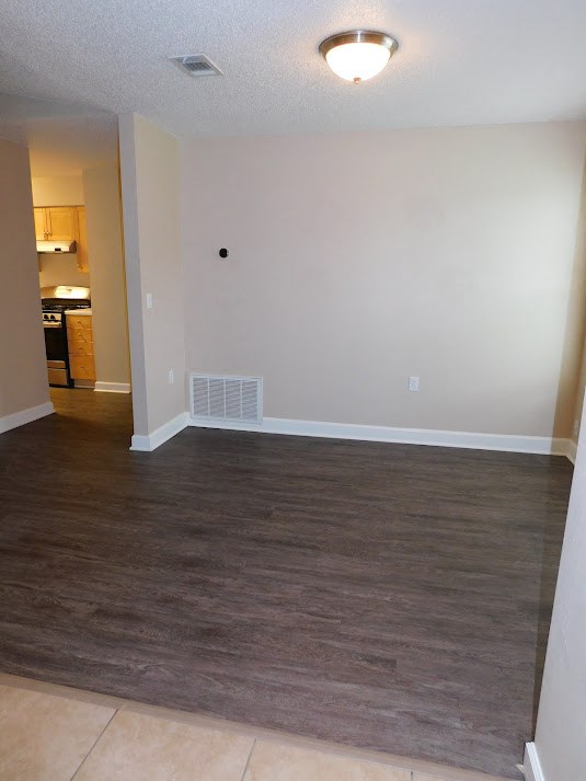 an empty living room with wood flooring and white walls