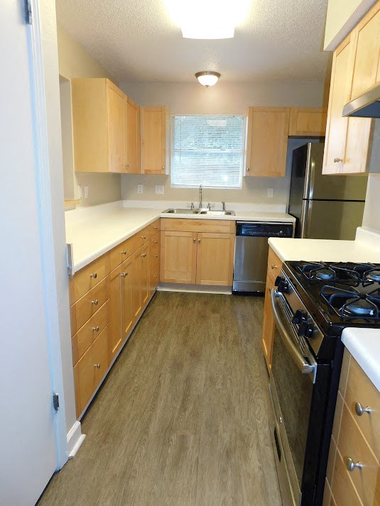 an empty kitchen with wooden cabinets and a stove