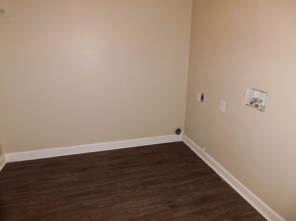 a room with a wood floor and white walls and