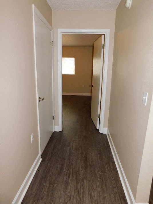 a hallway with a wood floor and a door to a room