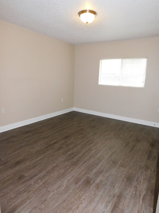 an empty room with wooden floors and a window