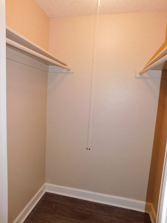 a walk in closet with a white wall and a sliding closet door