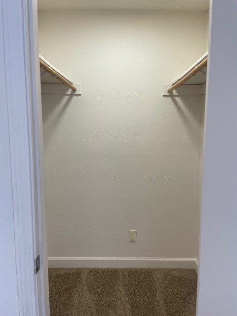 an empty closet with two shelves on the wall