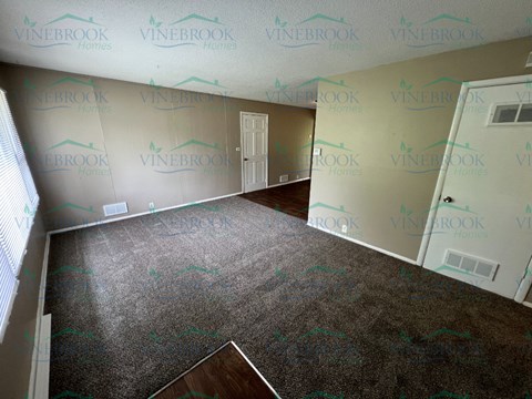 a living room with carpet and walls covered in wallpaper
