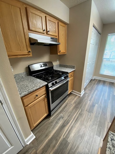 a kitchen with wooden floors and a stove and a microwave