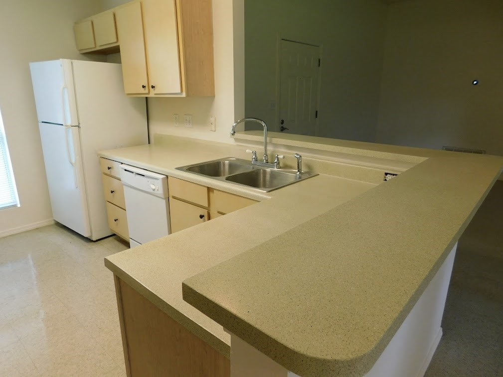 a kitchen with an island and a sink and a refrigerator