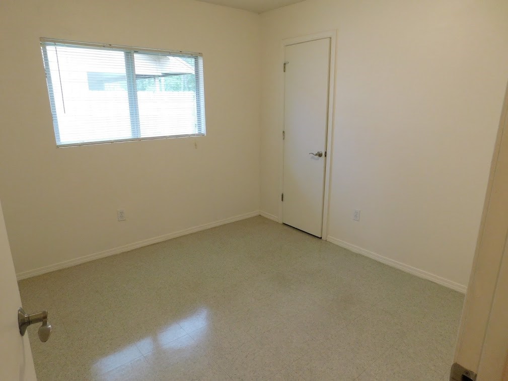 an empty room with a door and a window