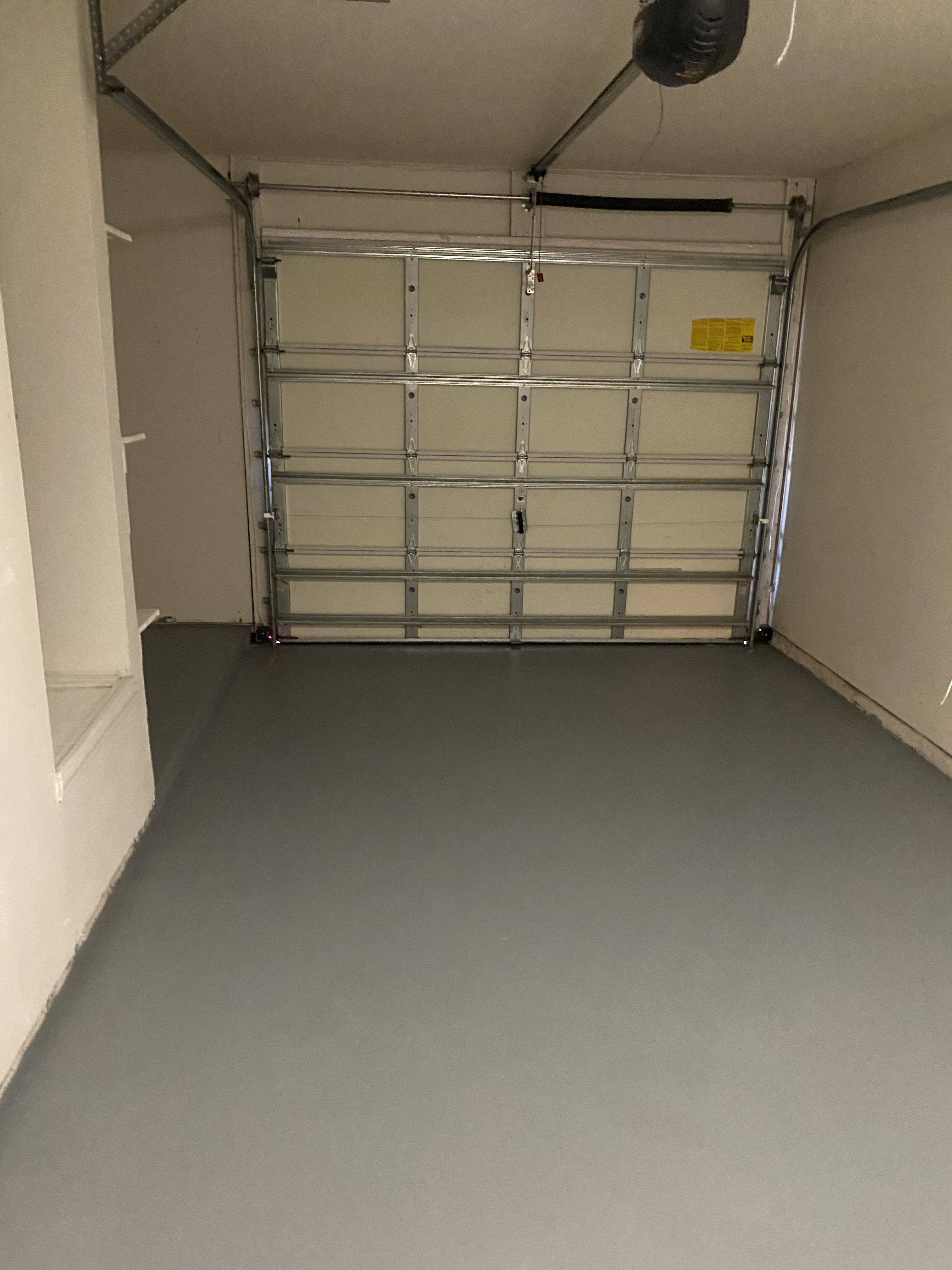 a garage with an empty floor and a metal garage door