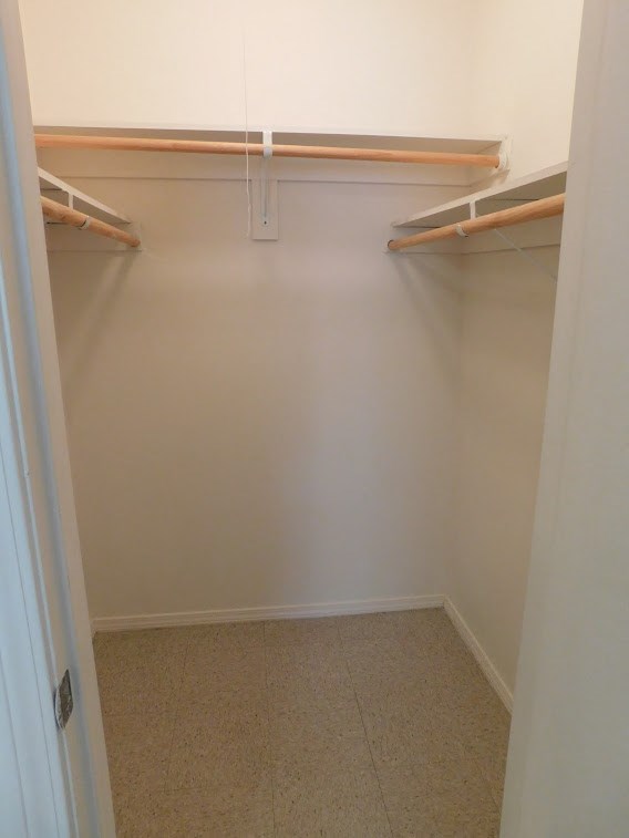 a walk in closet with two empty shelves